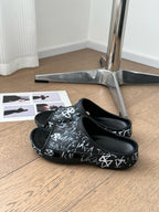 POOL GRAFFITI CROCS SLIDE SANDALS IN BLACK AND WHITE RUBBER