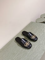 FLAT MULES IN BLACK SMOOTH CALFSKIN GOLD BUCKLE