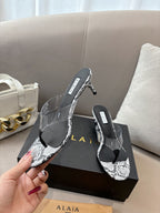 ALAIA HEELED THONG 25S 55 MM IN WHITE AND BLACK LAMBSKIN SNAKE-EMBOSSED WITH CLEAR STRAP