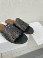 ALAIA VIENNE FLAT MULES IN BLACK LAMBSKIN