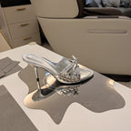 BOW-EMBELLISHED HIGH MULES IN SILVER METALLIC SHEEPSKIN